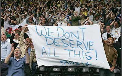 Leeds fans protest with a flag saying 'We don't deserve all this'.